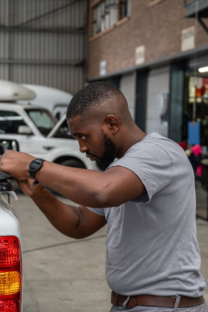 Auto Enhance technician fitting an accessory to a white bakkie