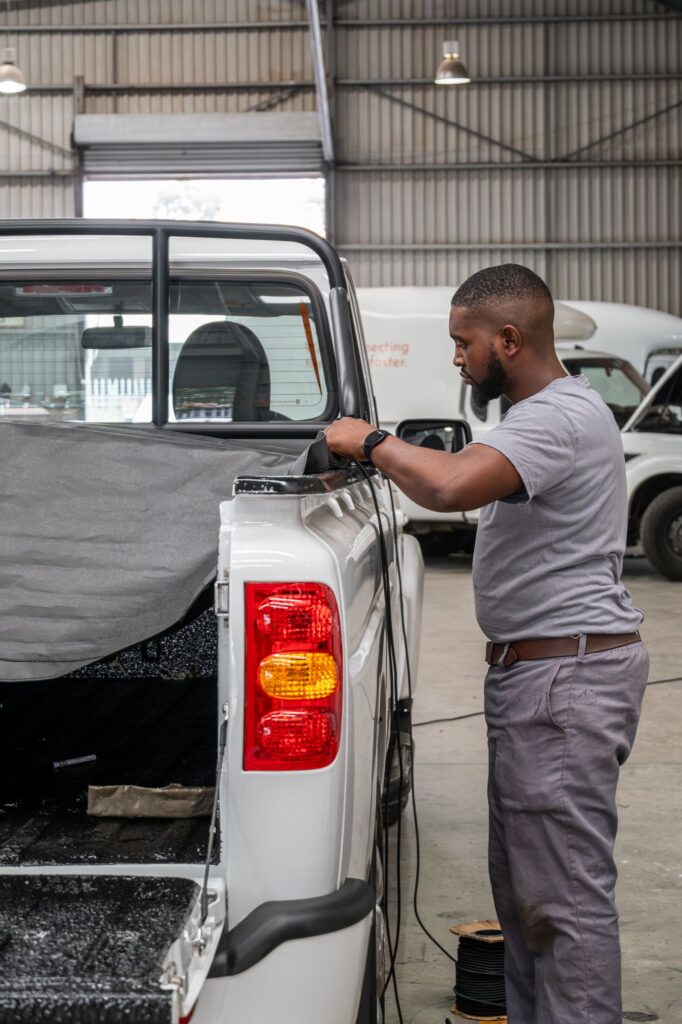 Auto Enhance technician fitting a bakkie accessory on site